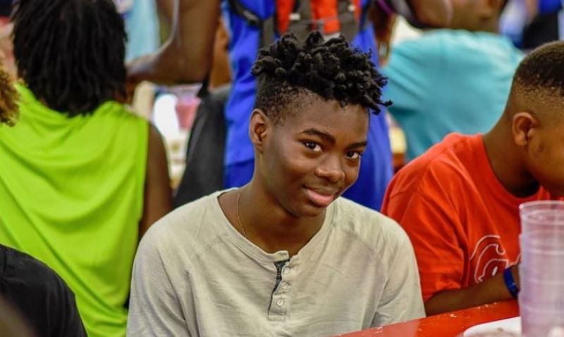 boy smiling while sitting at a lunch table